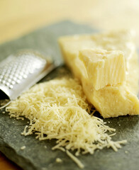 Grated parmesan cheese on a wooden board with grater