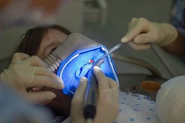 Kleinkind in der Zahnarztklinik durch Sedierungszahnheilkunde. Der Zahnarzt behandelt Zahn.