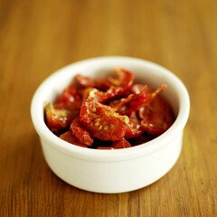 Sunblush sundried tomatoes with oil in white ceramic bowl