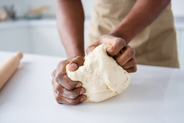 Cropped close-up view of nice hands guy confectioner making fresh bread pie pide doughing flour...