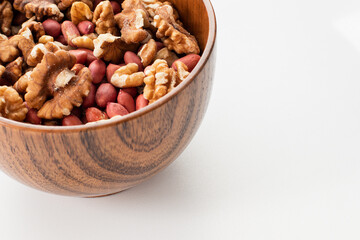 Mix of nuts in a wooden bowl on a white background