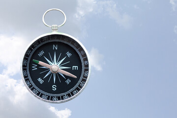round compass on blue cloudy sky background as symbol of tourism with compass, travel with compass and outdoor activities with compass