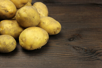 Raw organic potatoes on a wooden background