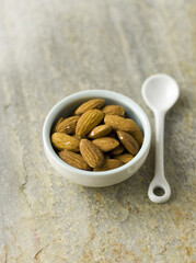 Almonds in blue bowl with white spoon