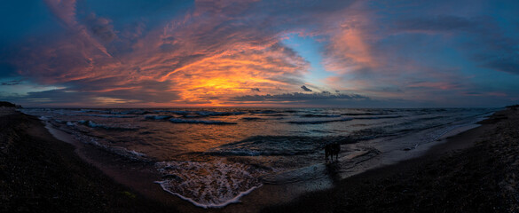 sunset by the sea with a bright picturesque cloudy sky, panorama