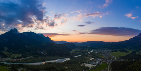 panorama of village pflach in austrian mountains with river lech at colorful sunset