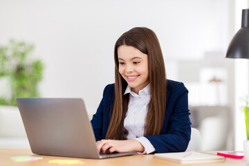 Photo of little pretty student school girl notebook online lesson video call sit desk distance quarantine study comfort 1 september autumn at home living room house classroom indoors