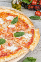 Margarita pizza with sliced slice on a wooden board