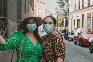 Two female woman wearing mask in the new normal in the street
