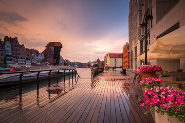 Old town in Gdansk with historical port crane over Motlawa river at rainy sunset, Poland.