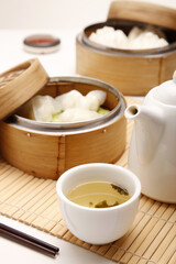 Dim sum in bamboo steamers with a pot of chinese tea