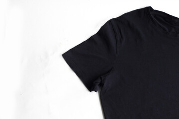 Black t-shirt on a white background. Cropped photo. Close up. Copy space. Men's t-shirt. Women's t-shirt.