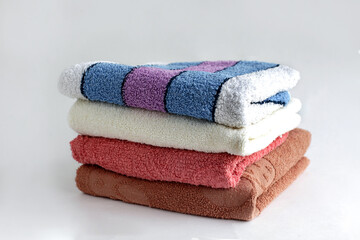 A stack of colored terry towels on a white background.