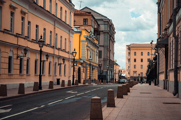A deserted narrow street in the Central part of the city with low-rise stone buildings
