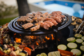 The chef grills meat and vegetables in the backyard