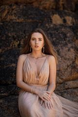 beautiful young woman in elegant dress on the beach