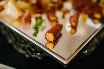 Pineapple rolled in prosciutto on a tray