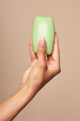 Hygiene Female hands are holding a soap on a beige background. Daily hygiene for the prevention of viral and bacterial infections.