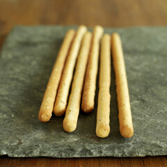 Italian sesame breadsticks on slate