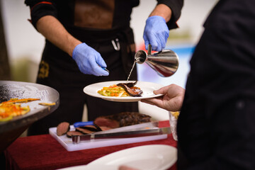 Obraz na płótnie Canvas The chef serves the dish on a plate. Steak topping
