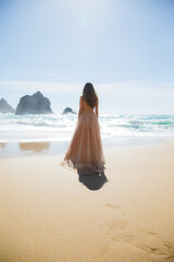 Young beautiful caucasian woman in long tull dress on coast of sea.