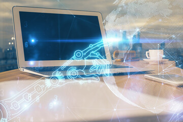 Computer on desktop in office with technology theme hologram. Multi exposure. Tech concept.
