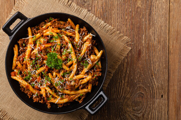 Maccheroni al ferretto with beef in ragu bolognese. Top view.