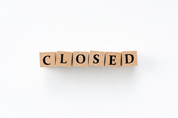 A block of wood with closed letters on a white background