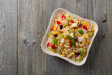 Salad with rice, chicken, peanuts and vegetables. Top view.