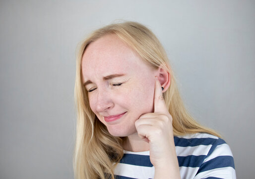 A woman suffers from pain in the ear. The auditory meatus hurts due to otitis media, cerumen plug, ear boil, or trigeminal neuralgia