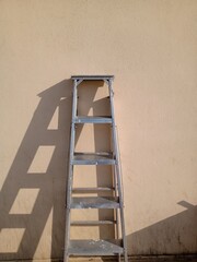 ladder with shadow to the wall during painting