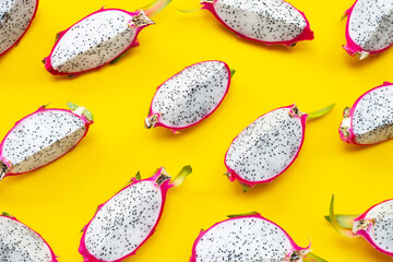 Ripe dragonfruit or pitahaya slices on yellow background.