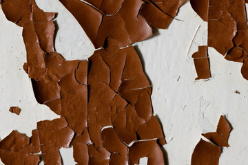Brown peeling paint on the wall. Old concrete wall with cracked flaking paint. Weathered rough...