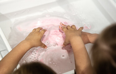 Hygiene and care, children wash their hands in the sink.