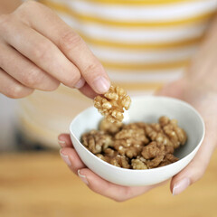 Woman's hands with a bowl of walnuts