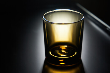 Empty glass on a matte black background with backlight
