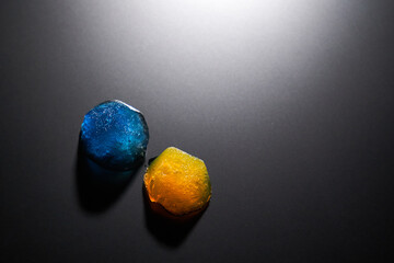 Two pieces of beautiful ice blue and orange on a matte surface with backlight top view