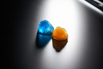 Two pieces of beautiful ice blue and orange on a matte surface with backlight