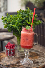 Cool smoothie with raspberries on a wooden background