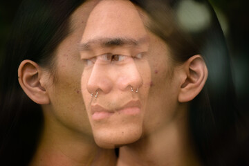 Obraz premium Young Asian man with long hair in the city with multiple exposure effect