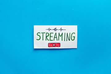 Live streaming concept - words on paper tablet on blue top view