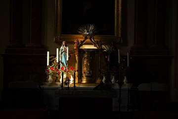 The sun shines on the altar of the temple and the statue of the Virgin Mary is illuminated by the...