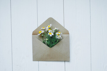 Flower heart in white envelope on wooden table