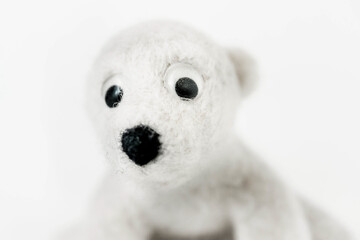 toy polar bear made of felted wool close up on white background