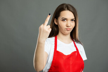 Naklejka premium Portrait of young female supermarket employee showing obscene gesture