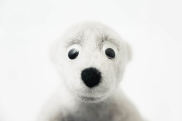 portrait of toy polar bear made of felted wool on white background