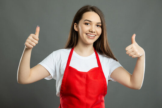 Portrait of female supermarket employee showing double thumb up