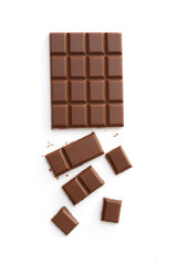Milk chocolate pieces isolated on white background from top view