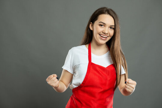 Portrait of young female supermarket employee making winner gesture
