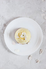 Raw food almond cake on a white plate. Vertical orientation, top view. Sugar free, gluten, lactose.